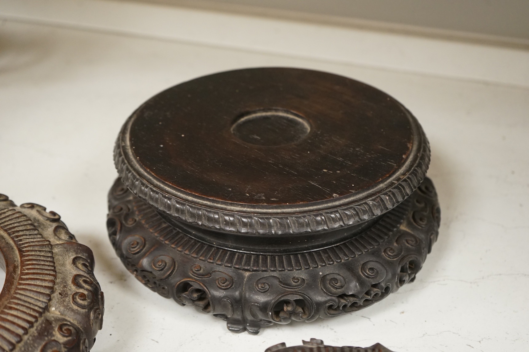 A collection of five Chinese and Japanese carved hardwood stands, late 19th/early 20th century, largest 25cm in diameter